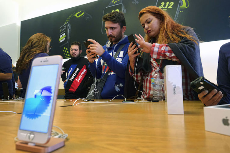 Customers check out the new Apple iPhone 7 at the Apple Store at the Grove in Los Angeles on Friday, Sept. 16, 2016. The latest Apple Watches and iPhone 7 were released Friday. (AP Photo/Richard Vogel)